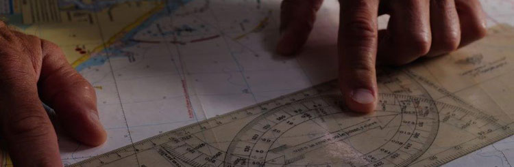 Enfoque cercano sobre las manos de una persona preparando un itinerario con la ayuda de un mapa y de una regla